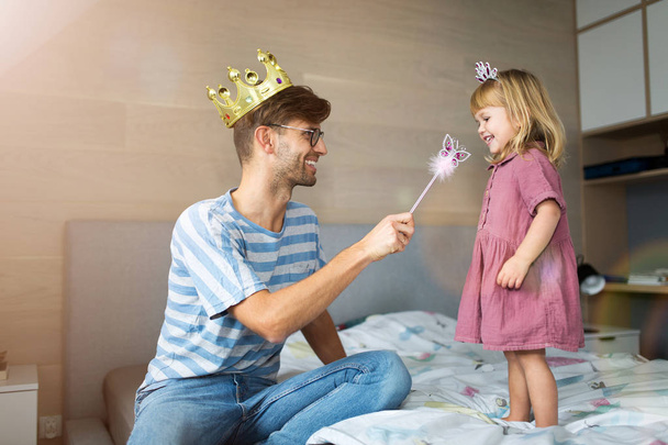 Father casting spell on daughter with magic wand - Valokuva, kuva