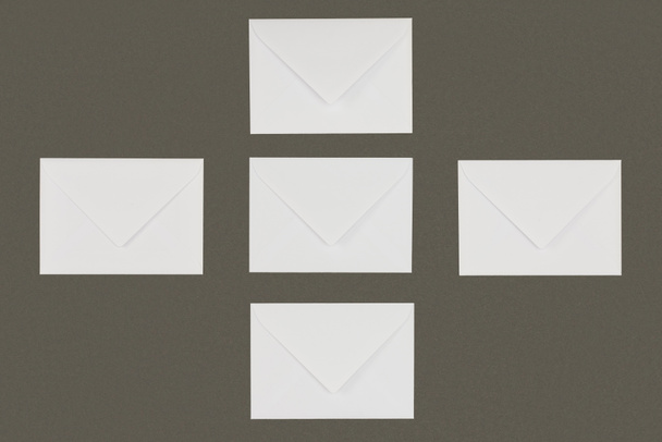 top view of white envelopes arranged isolated on grey background - Foto, afbeelding