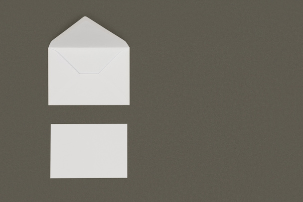 vista superior do envelope branco aberto e cartão em branco isolado no fundo cinza
 - Foto, Imagem