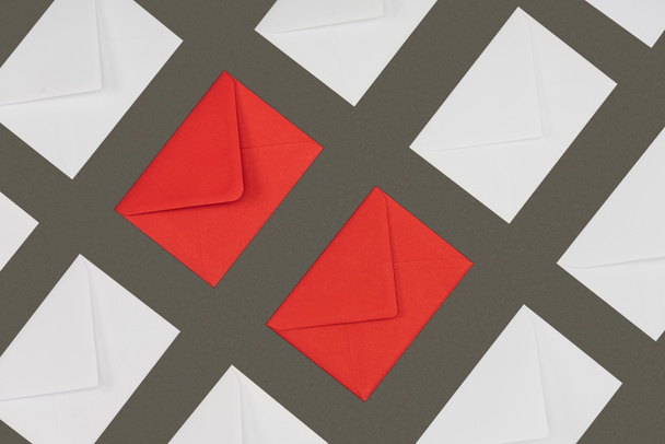 geschlossene rote und weiße Umschläge isoliert auf grauem Hintergrund  - Foto, Bild
