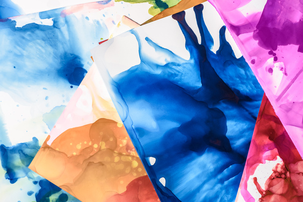 brown, blue and red splashes of alcohol inks on paper sheets as abstract background - 写真・画像