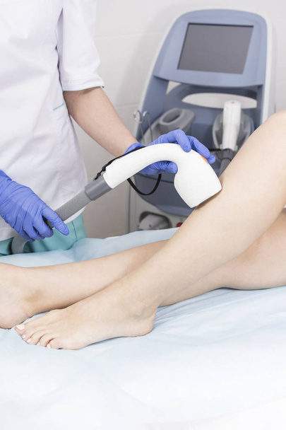 The process of laser depilation of female limbs in the beauty salon.  - 写真・画像