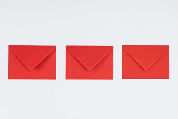 vue rapprochée de trois enveloppes rouges fermées isolées sur fond blanc
 - Photo, image