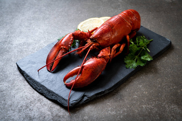 red lobster with vegetable and lemon on black slate plate - Фото, изображение