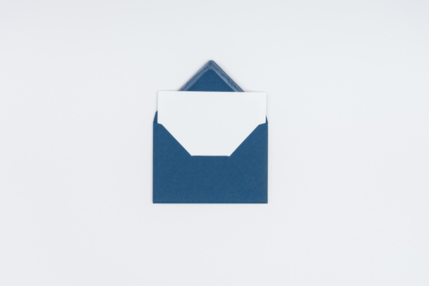 close-up view of blue open envelope with blank white card isolated on white - Фото, изображение