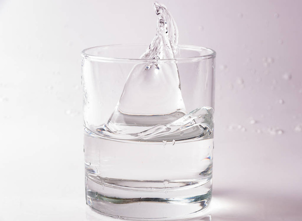 Ποτήρια νερού που υπάγονται και άλμα με πιτσιλιές και σταγόνες - Φωτογραφία, εικόνα