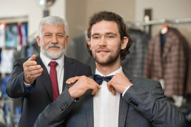 Two happy atractive elegant men choosing clothes for special occaision.  - Foto, Imagem