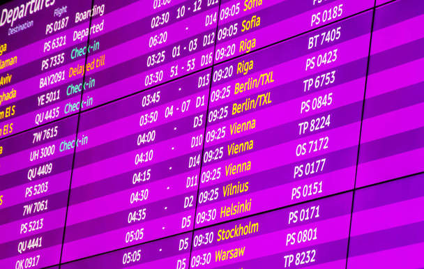 Check-in, Infotafel für Abflug und Ankunft am Flughafen, violett, rosa Farbe, Nahaufnahme - Foto, Bild