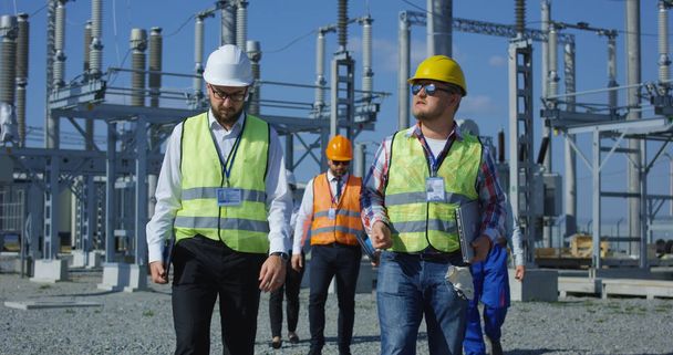 Group of engineers walking on solar station platform - Photo, Image