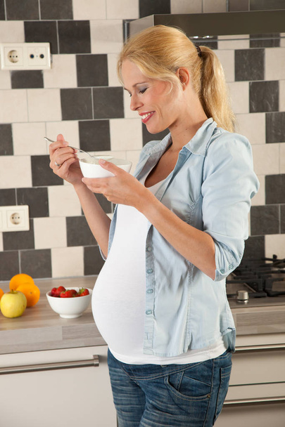 Attractive young woman having healthy lunch while being pregnant - Fotografie, Obrázek