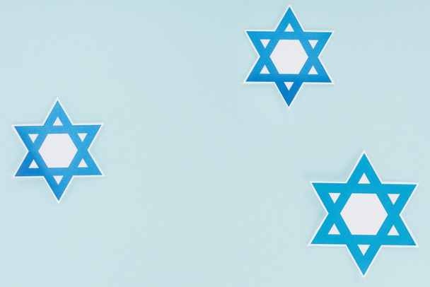płaskie lay z tradycyjnych żydowskich gwiazdek na białym tle na niebiesko, hannukah wakacje koncepcja - Zdjęcie, obraz
