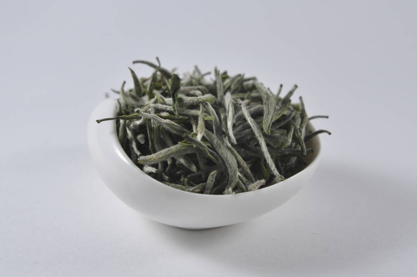 Té verde chino en vajilla de té. Hoja de té seca. Foto de producto de té chino. Té e infusiones. Montón de té seco
. - Foto, imagen