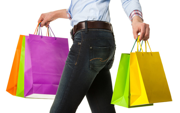 Woman holding multicolored shopping paper bags - 写真・画像