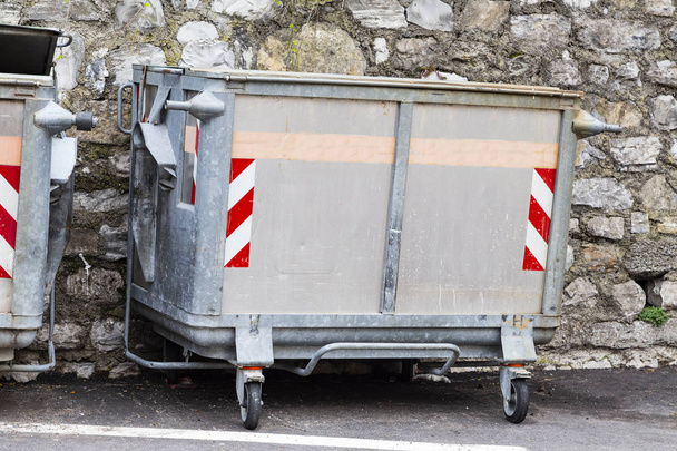Výpis popelnici na ulici nedaleko concret zdi pro odpad v Evropě - Fotografie, Obrázek