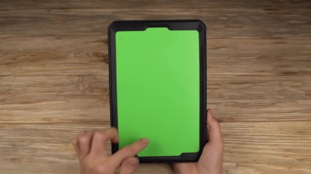 Una donna tiene un tablet PC con uno schermo verde per il proprio contenuto personalizzato
. - Filmati, video