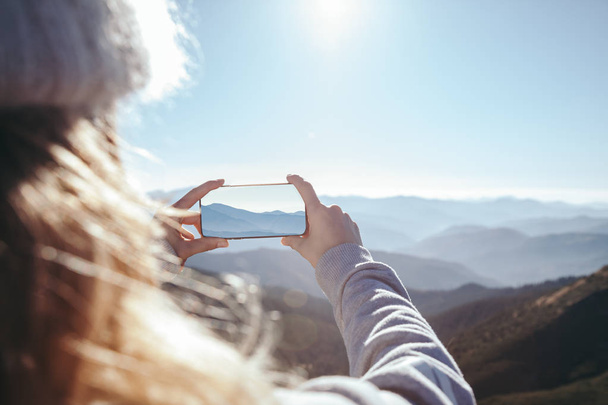 tiro cortado de mulher tirando foto de montanha com smartphone, Cárpatos, Ucrânia
 - Foto, Imagem