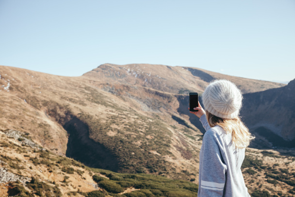 takana näkymä nainen ottaa valokuvan vuoren älypuhelimen tyhjällä näytöllä, Karpaatit, Ukraina
 - Valokuva, kuva