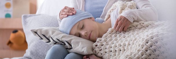 Panorama of caregiver supporting sleeping sick child with cancer in the hospice - Фото, зображення