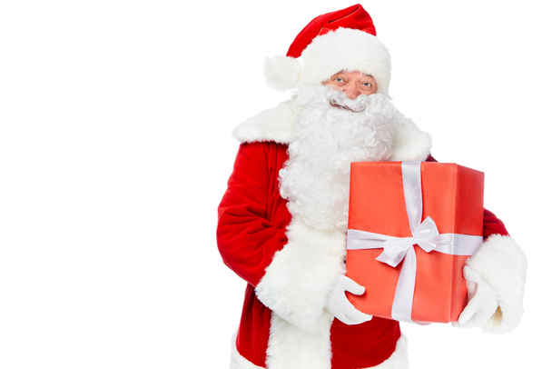 happy santa claus holding red christmas gift isolated on white - Fotografie, Obrázek