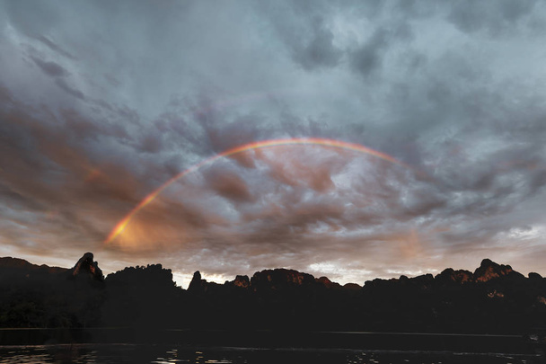 Naturaleza de montaña y fondo del lago con arco iris brillante en el cielo nublado dramático, Tailandia
 - Foto, imagen