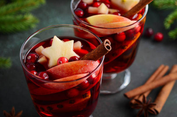 Christmas Mulled Wine with Apple, Orange and Cranberries. Holiday Concept Decorated with Fir Branches, Cranberries and Spices. - Foto, afbeelding