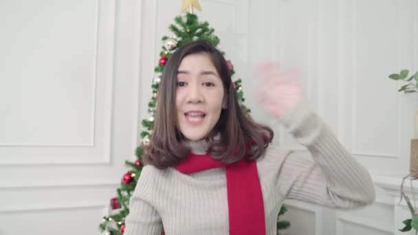 Cheerful happy young Asian woman holding christmas gifts smiling to camera in her living room at home in Christmas Festival. Lifestyle woman celebrate Christmas and New year concept. - 映像、動画