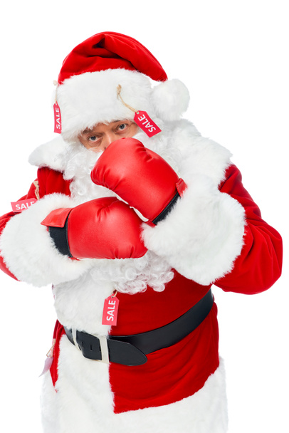 Weihnachtsmann in Boxhandschuhen und rotem Kostüm mit Verkaufsetiketten auf weißem Grund - Foto, Bild