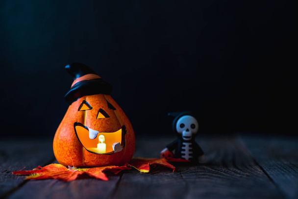 pumpkin in a hat with a face and a skeleton in a hoodie - Foto, Bild