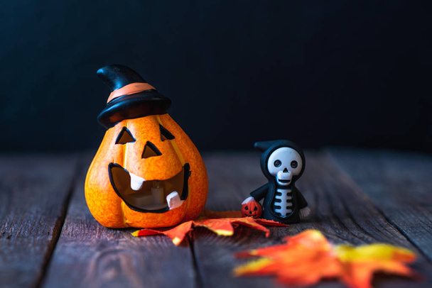 pumpkin in a hat with a face and a skeleton in a hoodie - Fotó, kép
