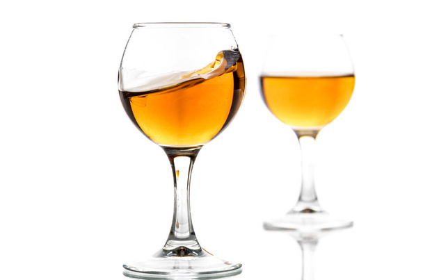 Круглый стакан с бренди и брызги напитка внутри
 - Фото, изображение