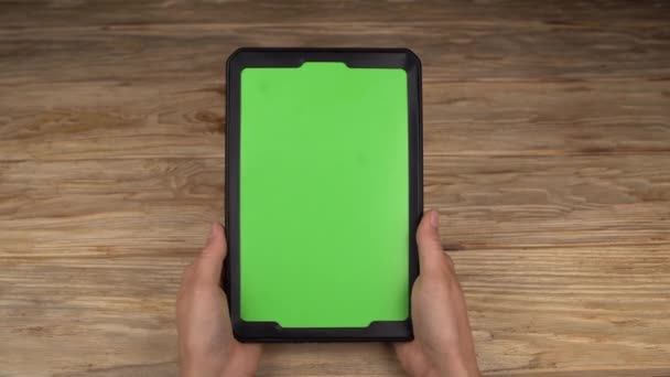 A woman holds a tablet PC with a green screen for your own custom content. - Footage, Video