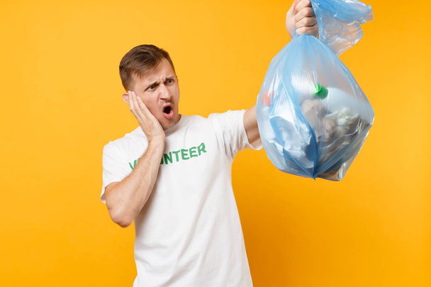 Homem de t-shirt voluntário segurar saco de lixo isolado em fundo amarelo. graça de caridade de assistência gratuita voluntária. Problema de poluição ambiental. Parar o conceito de proteção ambiental lixo natureza
 - Foto, Imagem