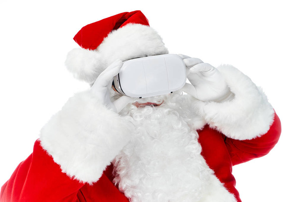 Санта-Клаус с использованием гарнитуры виртуальной реальности, изолированной на белом
 - Фото, изображение