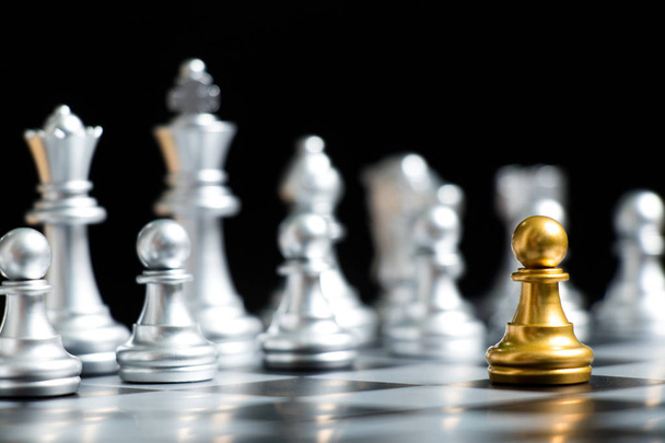 Zlaté pěšec šachové kus tvář s stříbrným týmem na černém pozadí (koncepci strategie firmy, obchodní rozhodnutí a setkání problém) - Fotografie, Obrázek