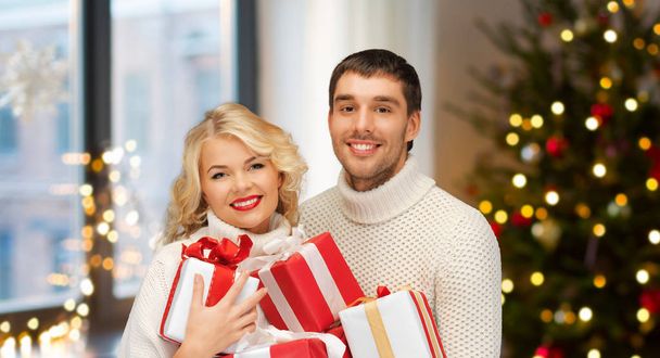 happy couple with christmas gifts at home - Foto, imagen
