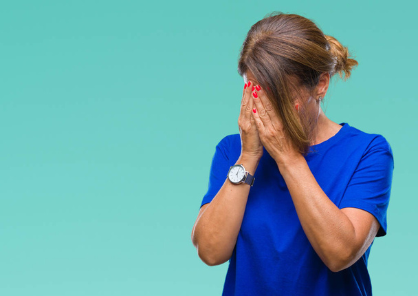 Старшая латиноамериканка среднего возраста на изолированном фоне с грустным лицом, прикрывающим лицо руками во время плача. Концепция депрессии
. - Фото, изображение