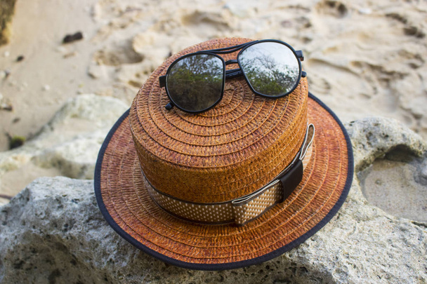 vista da vicino del cappello da barca con occhiali da sole sulla spiaggia
 - Foto, immagini
