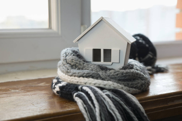 冬の暖房システムのコンセプトとニット帽を着て家のモデルと雪の降る寒さの家 - 写真・画像