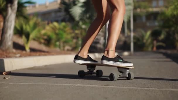 基板のスケーター足のクローズ アップ。スローモーションで道路に乗ってロングボード - 映像、動画