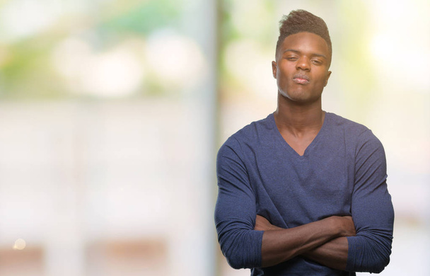 Fiatal afroamerikai férfi szkeptikus elszigetelt háttér és ideges, rosszalló kifejezés arcán keresztezett karokkal. Negatív személy. - Fotó, kép