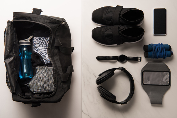 flat lay with sports bag and arranged sports equipment on white and marble  - Foto, Bild