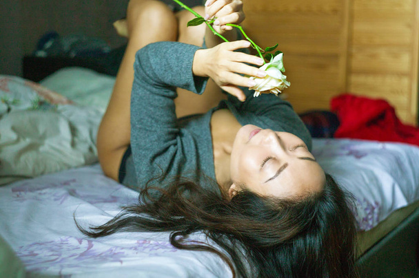 Beautiful asian woman in bed with white rose in the morning. - Foto, immagini