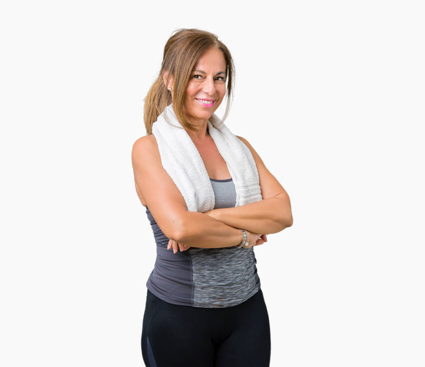 Beautiful middle age woman wearing sport clothes and a towel over isolated background happy face smiling with crossed arms looking at the camera. Positive person. - Photo, Image