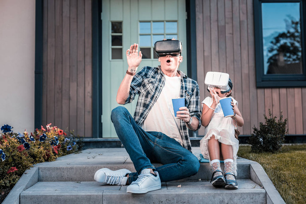 Emotional father and daughter feeling scared wearing virtual reality glasses - Fotografie, Obrázek