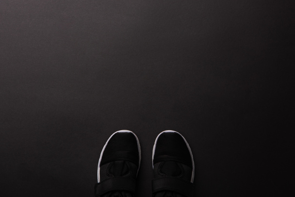 top view of sportive shoes isolated on black, minimalistic concept  - Photo, Image