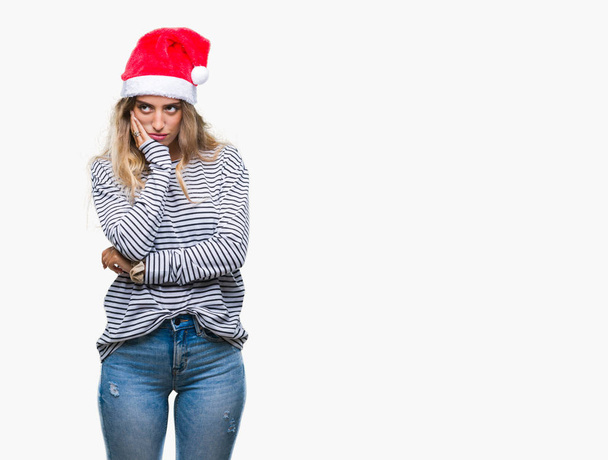 Kaunis nuori blondi nainen yllään joulu hattu yli eristetty tausta ajattelu näyttää väsynyt ja kyllästynyt masennus ongelmia ristissä kädet
. - Valokuva, kuva
