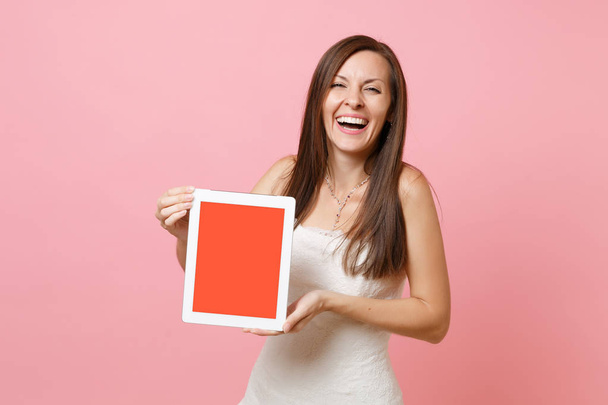 Muotokuva nauraa morsian nainen hääpuku pidä tabletti tietokone tyhjä musta tyhjä näyttö eristetty pastelli vaaleanpunainen tausta. Häät tehdä lista. Juhlan järjestäminen. Kopioi tila
 - Valokuva, kuva
