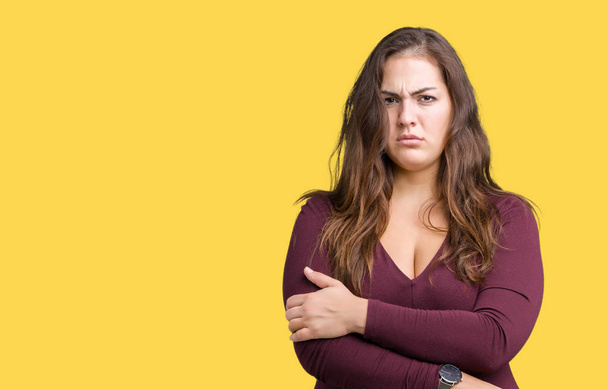 Beautiful and attractive plus size young woman wearing a dress over isolated background skeptic and nervous, disapproving expression on face with crossed arms. Negative person. - Photo, Image