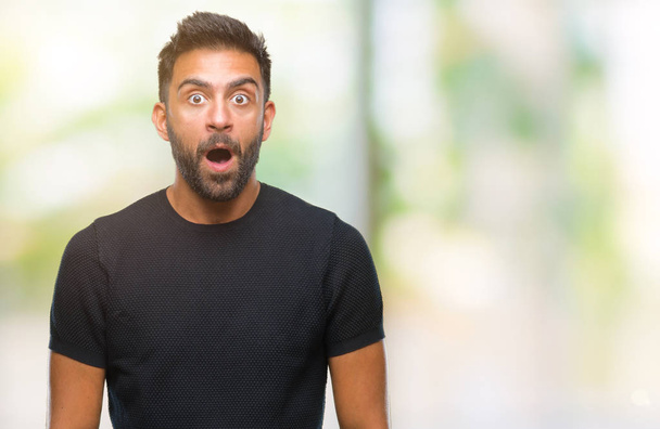 Adult hispanic man over isolated background afraid and shocked with surprise expression, fear and excited face. - Photo, Image