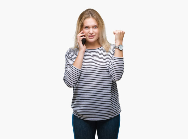 Genç kafkas kadın gösteren smartphone ekran üzerinde izole arka plan ile öfke, çılgın ve yükseltilmiş eliyle diye bağıran rahatsız ve hayal kırıklığına uğramış öfke kavramı bağırarak - Fotoğraf, Görsel